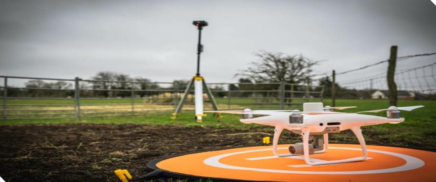 Drone on landing pad next to a GNSS base